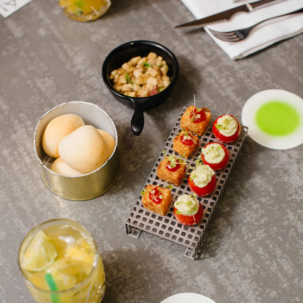 Brazilské sýrové pečivo pão de queijo a malé předkrmy v restauraci Brasileiro.